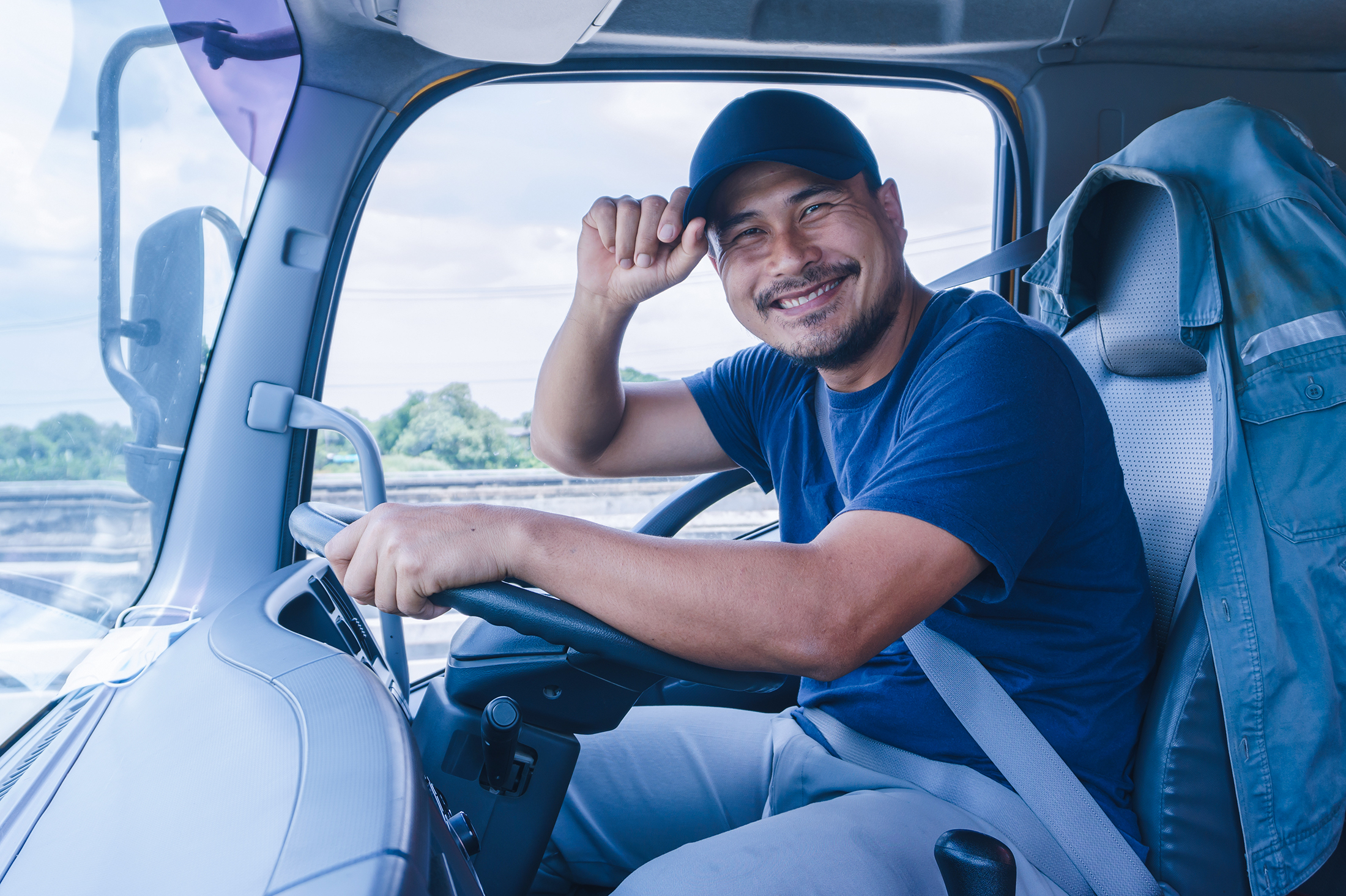 caminhoneiro sorridente em uma cabine de caminhão